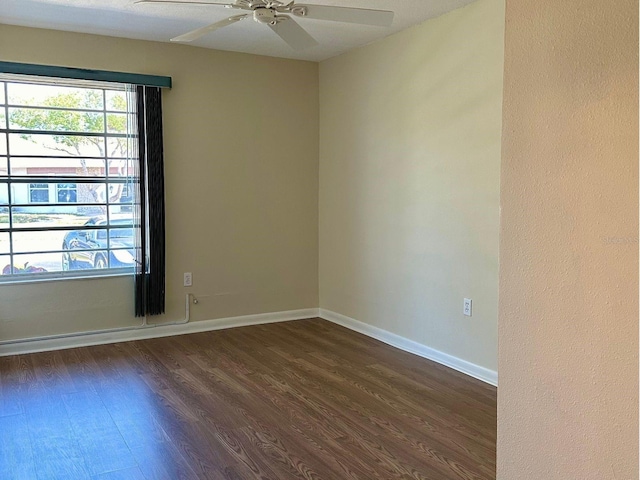 empty room featuring ceiling fan and dark hardwood / wood-style flooring