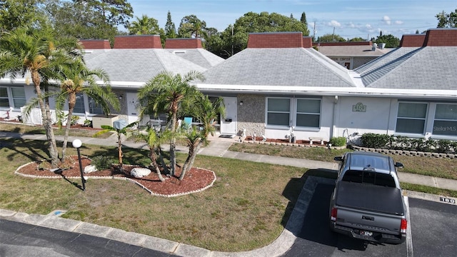 4329 Tahitian Gardens Cir Unit B, Holiday, FL 34691 - single story home with a shingled roof, a front lawn, and stucco siding