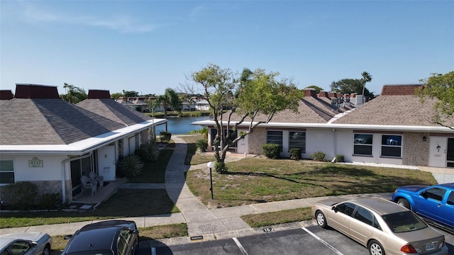 4329 Tahitian Gardens Cir Unit B, Holiday, FL 34691 - single story home with uncovered parking, stucco siding, a front yard, and a water view
