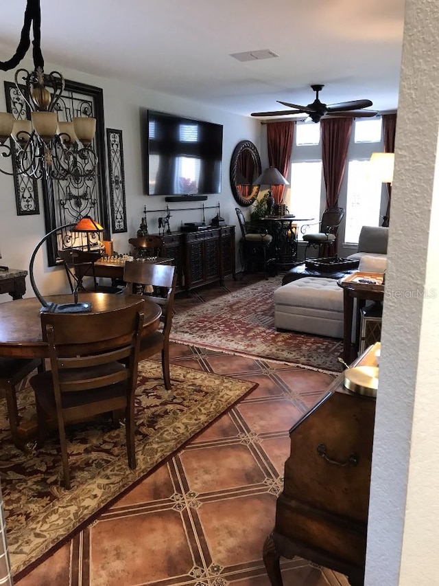 tiled living room featuring ceiling fan with notable chandelier