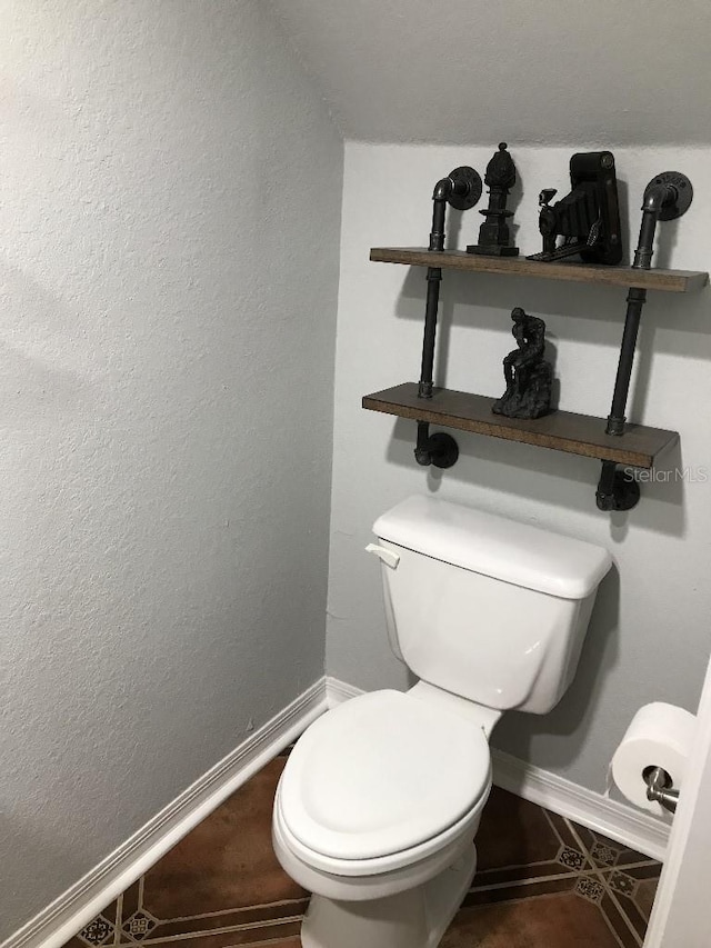 bathroom featuring toilet and tile floors