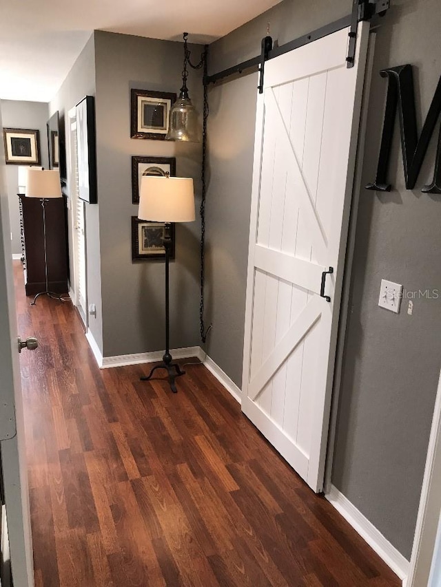 hall featuring a barn door and dark hardwood / wood-style flooring