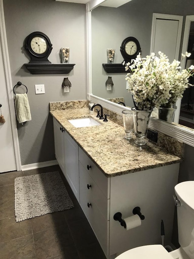 bathroom featuring tile floors, vanity with extensive cabinet space, and toilet