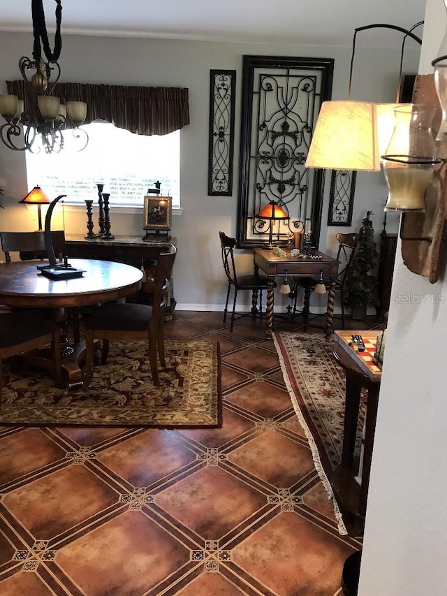 dining room featuring tile flooring, ornamental molding, and a notable chandelier