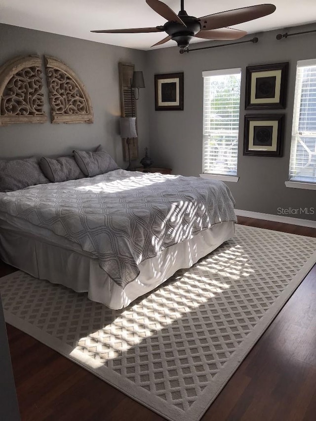 bedroom with ceiling fan and dark wood-type flooring