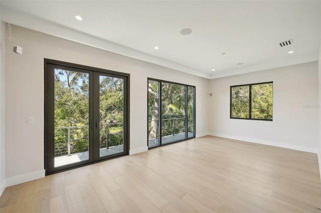 unfurnished room featuring a healthy amount of sunlight and light wood-type flooring