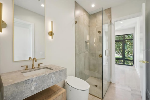 bathroom with a shower with door, vanity, and toilet