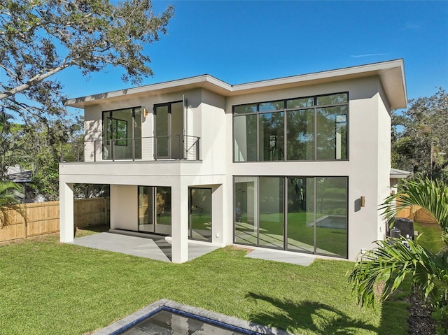 back of property with a patio area, a balcony, and a yard