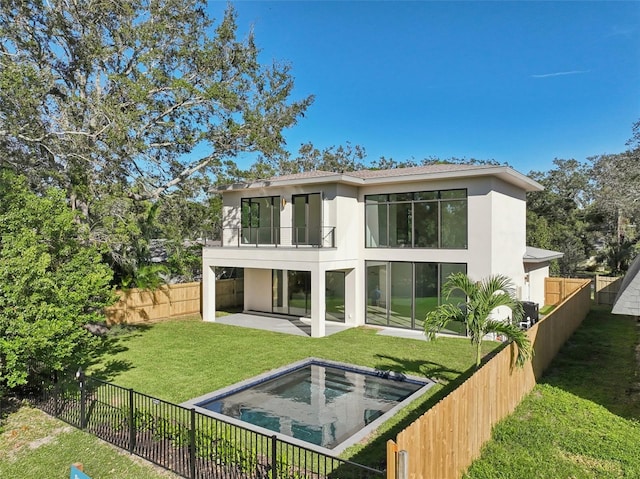 rear view of house featuring a lawn, a balcony, a patio, and a fenced in pool