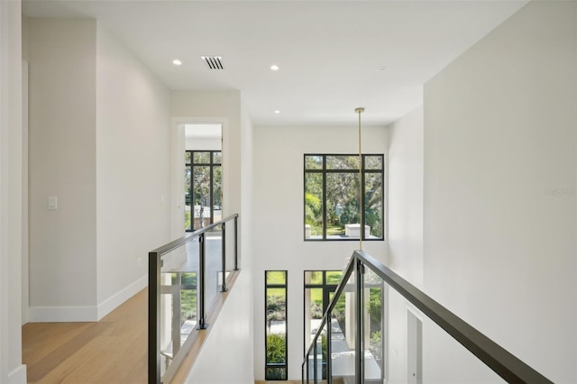 corridor with light wood-type flooring and plenty of natural light