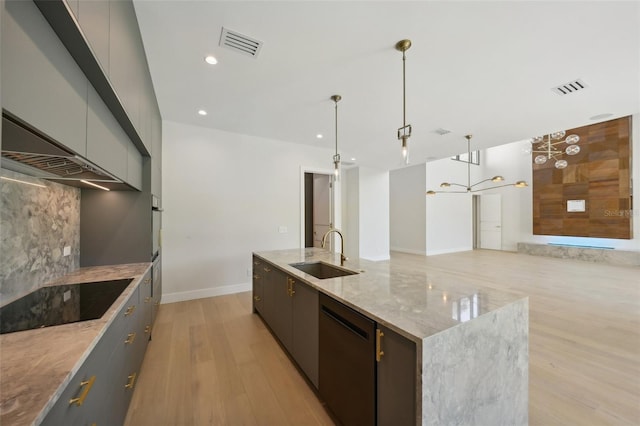 kitchen featuring stainless steel dishwasher, a spacious island, sink, pendant lighting, and gray cabinets