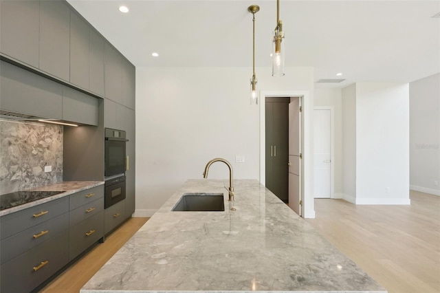 kitchen with gray cabinets, sink, decorative light fixtures, and black electric stovetop