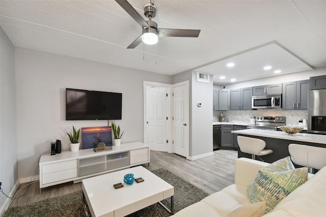 living room with hardwood / wood-style floors and ceiling fan