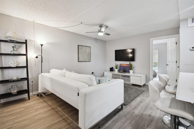 living room with wood-type flooring and ceiling fan