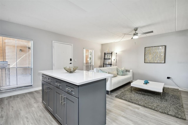 kitchen featuring a center island, gray cabinetry, light hardwood / wood-style flooring, and ceiling fan