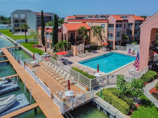 view of pool with a boat dock and a patio