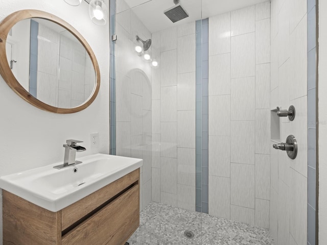 bathroom with tiled shower and oversized vanity