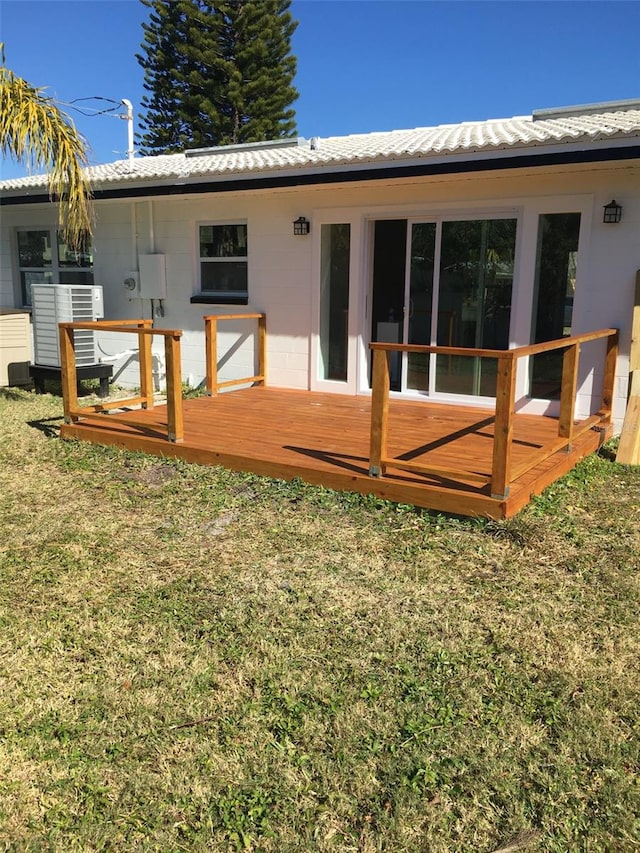 back of house featuring a deck and a lawn