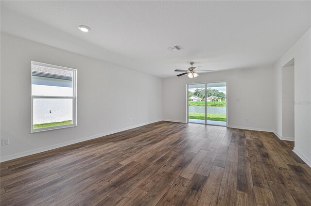 empty room with ceiling fan and dark wood-type flooring