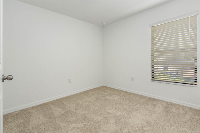 spare room featuring light colored carpet