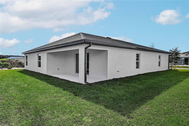 back of property with a patio area and a lawn