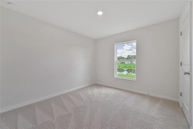 carpeted spare room with a water view