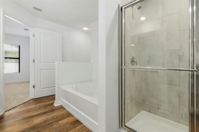 bathroom with separate shower and tub and hardwood / wood-style floors