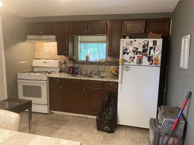 kitchen featuring white appliances, light tile patterned floors, dark brown cabinets, and sink