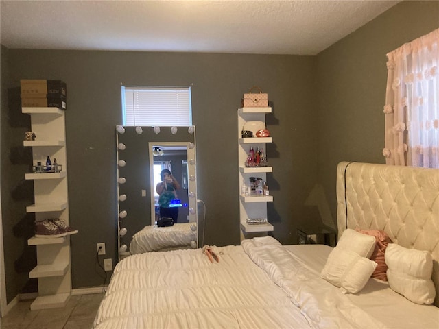 tiled bedroom featuring a textured ceiling