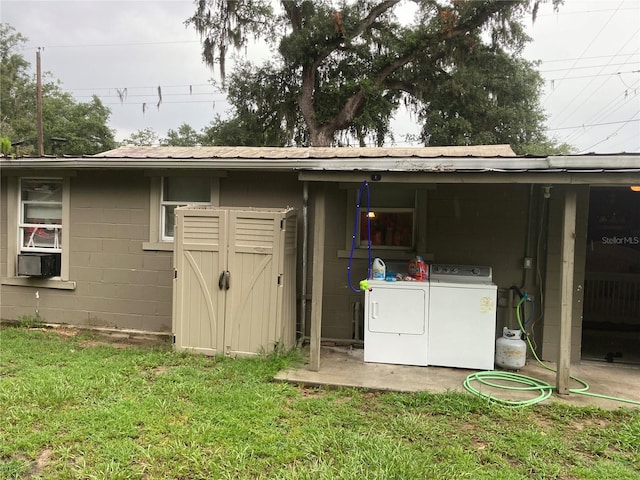 back of property featuring a yard and washing machine and clothes dryer