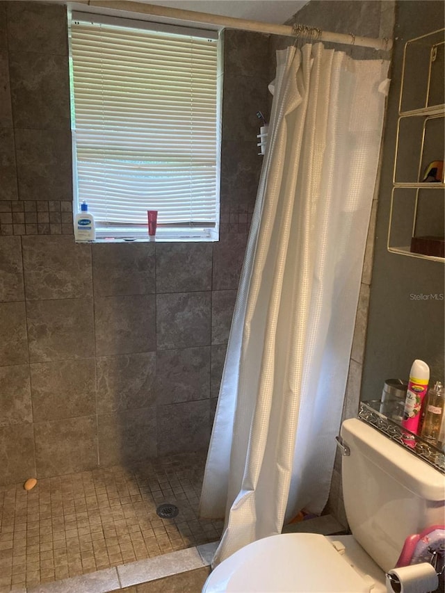 bathroom featuring toilet, walk in shower, and tile patterned flooring