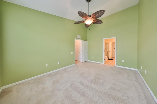 unfurnished bedroom with light carpet, ensuite bath, high vaulted ceiling, and ceiling fan