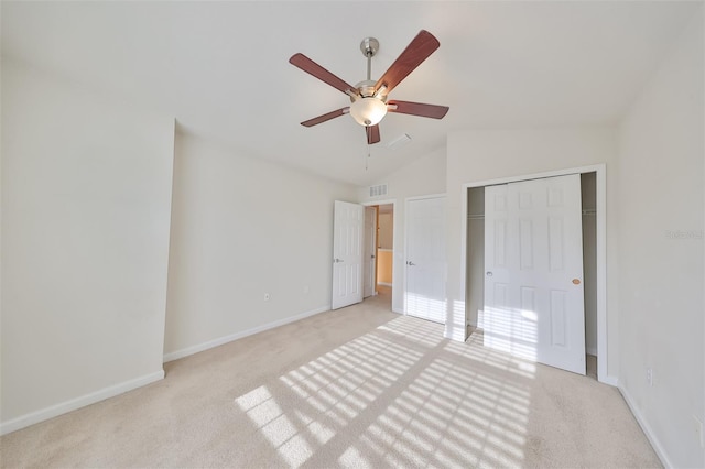 unfurnished bedroom featuring vaulted ceiling, ceiling fan, light carpet, and a closet