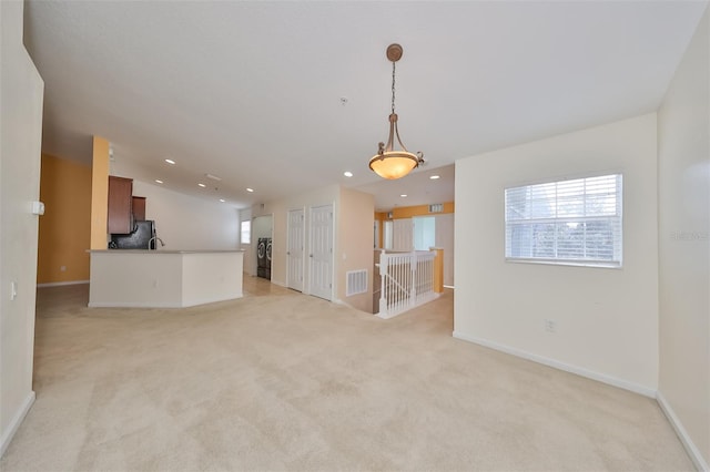 spare room featuring lofted ceiling and light colored carpet