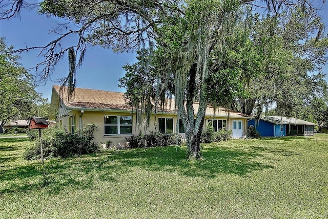 rear view of property featuring a yard