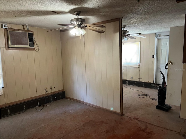 spare room featuring a textured ceiling, a wall mounted air conditioner, and ceiling fan