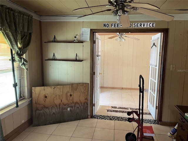 interior space featuring wood walls and ceiling fan