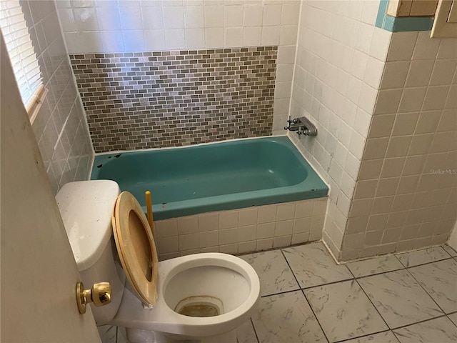 bathroom featuring toilet, tile flooring, and tile walls