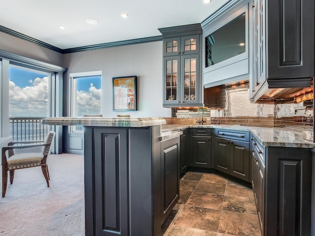 kitchen featuring decorative backsplash, glass insert cabinets, a peninsula, crown molding, and recessed lighting