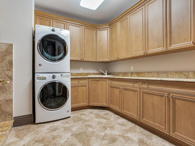 laundry area featuring a sink, cabinet space, and stacked washer / drying machine