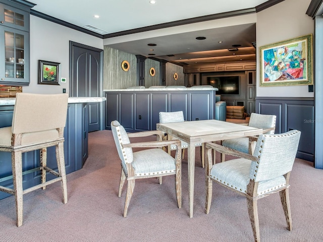 dining room with light carpet, ornamental molding, a decorative wall, and recessed lighting