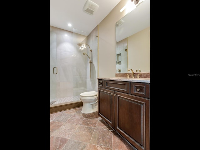 bathroom featuring visible vents, toilet, a stall shower, stone finish floor, and vanity