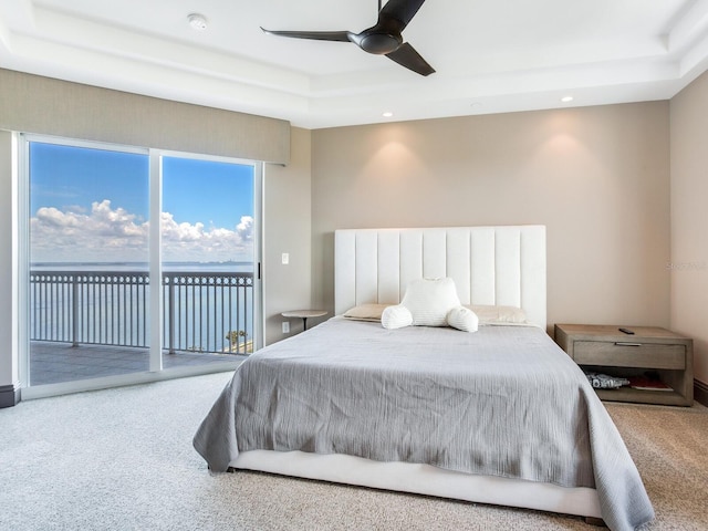 bedroom featuring access to exterior, a tray ceiling, carpet flooring, and recessed lighting