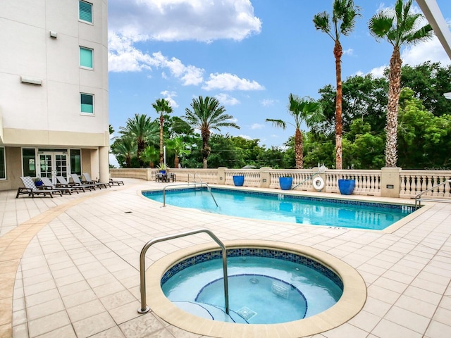 pool with a community hot tub, french doors, a patio, and fence