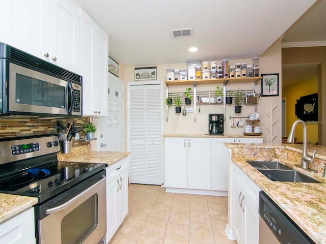 kitchen featuring light stone countertops, appliances with stainless steel finishes, sink, white cabinets, and tasteful backsplash