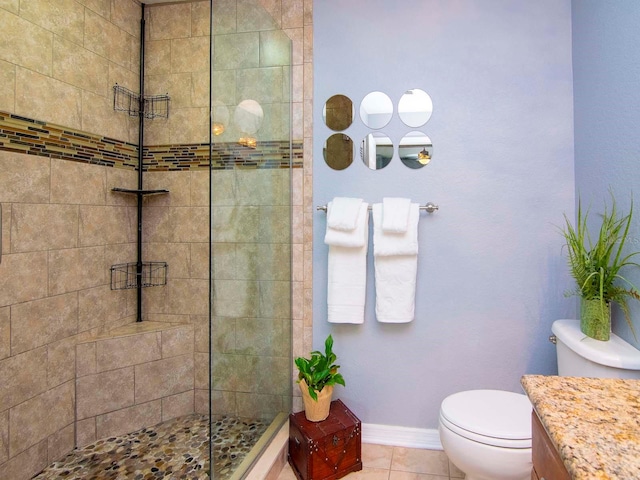 bathroom featuring vanity, toilet, tile floors, and a shower with door