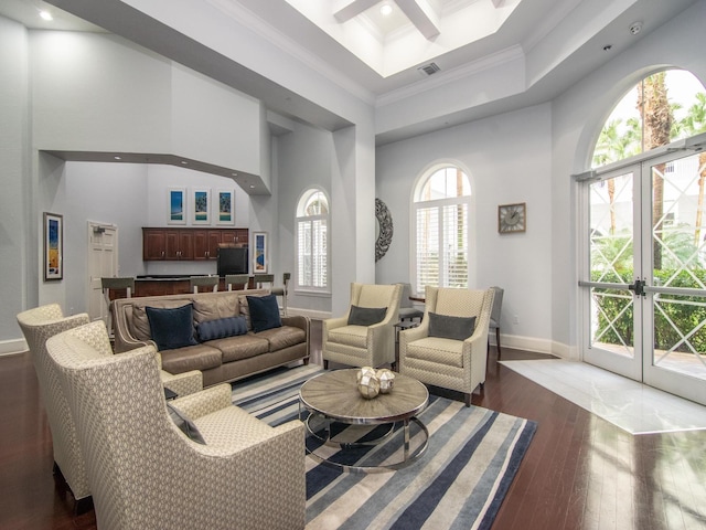 living room with a high ceiling, dark hardwood / wood-style floors, and ornamental molding