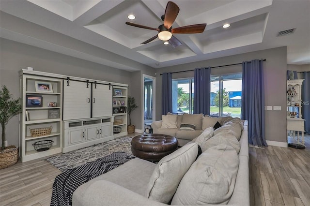 living room featuring coffered ceiling, ceiling fan, a barn door, and light hardwood / wood-style floors