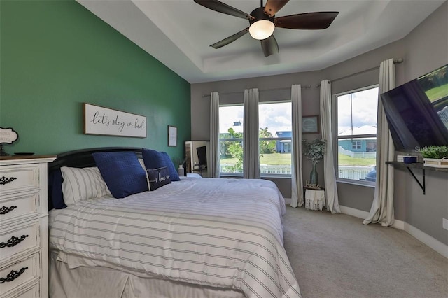 bedroom featuring ceiling fan, light carpet, and multiple windows