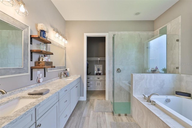 bathroom with vanity, shower with separate bathtub, and wood-type flooring